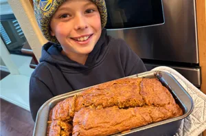 child holding loaf of pumpkin bread